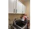 Bright laundry room with upper white cabinets above the modern washer and dryer machines at 1747 Wood Brook St, Tarpon Springs, FL 34689