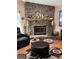 Cozy living room featuring a stone fireplace, plush seating, and warm decor at 1747 Wood Brook St, Tarpon Springs, FL 34689