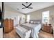 Spacious main bedroom with a ceiling fan, two windows, comfortable bed, and wooden furniture creates a cozy retreat at 1747 Wood Brook St, Tarpon Springs, FL 34689