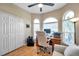 Bright home office boasts hardwood floors, arched windows, a desk with a computer, and a comfortable chair at 1747 Wood Brook St, Tarpon Springs, FL 34689