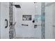 Luxurious shower features modern fixtures, white and mosaic tiling, and convenient shelving for toiletries at 1747 Wood Brook St, Tarpon Springs, FL 34689
