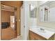 Bathroom with single vanity, large mirror, and neutral color palette at 1831 Stable Trl, Palm Harbor, FL 34685