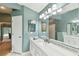 This bathroom is bright with an extra-long vanity, mirror, and multiple overhead light fixtures at 1831 Stable Trl, Palm Harbor, FL 34685