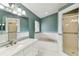 Bright bathroom featuring a marble-tiled soaking tub and a separate glass-enclosed shower at 1831 Stable Trl, Palm Harbor, FL 34685