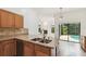 This kitchen has stainless steel dishwasher and double sink with view to pool at 1831 Stable Trl, Palm Harbor, FL 34685