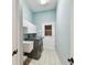 Bright laundry room includes washer, dryer, wash basin, storage, and convenient exterior access at 1831 Stable Trl, Palm Harbor, FL 34685