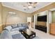 This living room features a sectional sofa, carpeting, a ceiling fan, and a large television at 1831 Stable Trl, Palm Harbor, FL 34685