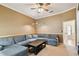 The living room is well-lit, with a sectional sofa and coffee table, and access to other rooms at 1831 Stable Trl, Palm Harbor, FL 34685