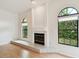 Light and airy living room featuring a fireplace and two arched windows at 1831 Stable Trl, Palm Harbor, FL 34685