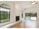 View of the well-lit living room with a fireplace and an open view of the refreshing pool area at 1831 Stable Trl, Palm Harbor, FL 34685