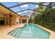 Refreshing pool surrounded by a screened lanai, beautiful landscaping, and ample deck space at 1831 Stable Trl, Palm Harbor, FL 34685