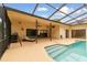 Inviting lanai featuring lounge seating, covered patio, and screened pool enclosure at 1831 Stable Trl, Palm Harbor, FL 34685