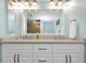 Double sink vanity in bathroom with granite countertops, cabinets and decorative lighting at 2021 Shangrila Dr # 14, Clearwater, FL 33763