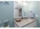 Inviting bathroom featuring a vanity with granite counters, framed mirror and nautical themed décor at 2021 Shangrila Dr # 14, Clearwater, FL 33763
