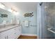 Bright bathroom featuring a double sink vanity, granite countertops and shower with glass doors at 2021 Shangrila Dr # 14, Clearwater, FL 33763