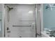 Clean bathroom with a white shower-tub and glass door, complemented with nautical themed décor at 2021 Shangrila Dr # 14, Clearwater, FL 33763