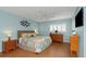 Cozy bedroom with coastal theme, wood flooring, two nightstands, and a TV at 2021 Shangrila Dr # 14, Clearwater, FL 33763