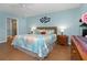 Bright bedroom with coastal themed comforter, nightstands, and access to the en-suite bathroom at 2021 Shangrila Dr # 14, Clearwater, FL 33763