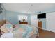 Light-filled bedroom with wood floors, coastal decor, closet, and entertainment center at 2021 Shangrila Dr # 14, Clearwater, FL 33763