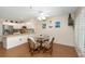 An inviting dining area with a round glass table, comfortable chairs, and a view of the modern kitchen at 2021 Shangrila Dr # 14, Clearwater, FL 33763