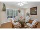 Bright dining space with a round glass table, seating for four, and a window with plantation shutters at 2021 Shangrila Dr # 14, Clearwater, FL 33763