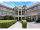 Exterior view of condo complex with palm trees, multiple balconies and a well manicured lawn at 2021 Shangrila Dr # 14, Clearwater, FL 33763