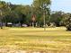 Lush green golf course view with mature trees and a flag waving in the breeze at 2021 Shangrila Dr # 14, Clearwater, FL 33763