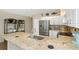 Open kitchen with stainless appliances, white cabinets, and granite countertops at 2021 Shangrila Dr # 14, Clearwater, FL 33763