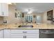 Open kitchen with stainless dishwasher and granite countertops overlooking dining area at 2021 Shangrila Dr # 14, Clearwater, FL 33763
