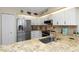 Kitchen features stainless steel appliances, granite counters, and white cabinetry at 2021 Shangrila Dr # 14, Clearwater, FL 33763