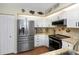 Bright kitchen features stainless steel appliances, granite counters, and white cabinetry at 2021 Shangrila Dr # 14, Clearwater, FL 33763