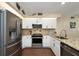Modern kitchen featuring stainless steel appliances, granite countertops, and white cabinets at 2021 Shangrila Dr # 14, Clearwater, FL 33763