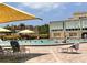 Community pool with shaded seating areas, lounge chairs and beautiful building views at 2021 Shangrila Dr # 14, Clearwater, FL 33763