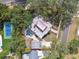 Aerial view of property showing house, pool, tennis court, and mature trees at 2710 N Dundee St, Tampa, FL 33629
