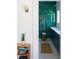 A contemporary bathroom featuring sleek green tiled walls, navy vanity, and modern fixtures at 2710 N Dundee St, Tampa, FL 33629