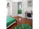 Bright bedroom with hardwood floors, a study space and view into a bathroom at 2710 N Dundee St, Tampa, FL 33629