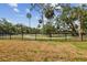 A serene community park with a walking trail and lush green space behind a black fence at 2710 N Dundee St, Tampa, FL 33629