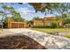 Long driveway leading to the brick home, with garage and landscaped yard at 2710 N Dundee St, Tampa, FL 33629