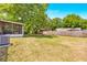 Spacious backyard featuring a wooden fence, lush lawn, and mature trees for privacy at 27343 Warner Ave, Brooksville, FL 34602