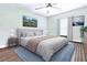 Digitally staged bedroom with neutral decor, ceiling fan and a cozy blue area rug at 27343 Warner Ave, Brooksville, FL 34602