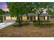 Well-lit single-story home with a manicured lawn and classic curb appeal at dusk at 27343 Warner Ave, Brooksville, FL 34602