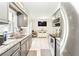 The open kitchen features grey cabinets, stainless steel appliances, and stone countertops at 27343 Warner Ave, Brooksville, FL 34602