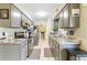 The kitchen features grey cabinets, stainless steel appliances and stone countertops at 27343 Warner Ave, Brooksville, FL 34602