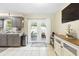 Functional kitchen with gray cabinets, tile flooring, and a view of the backyard at 27343 Warner Ave, Brooksville, FL 34602