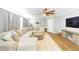Spacious living room with a comfortable sectional couch, modern fan, and hardwood floors at 27343 Warner Ave, Brooksville, FL 34602
