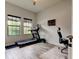 Bright home gym with treadmill, desk, and natural light from large windows at 2826 Riders Pass, Odessa, FL 33556