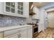 Kitchen showcases white cabinetry, mosaic tile backsplash, and stainless steel gas range at 2826 Riders Pass, Odessa, FL 33556