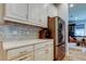 Kitchen featuring modern cabinets, mosaic backsplash, a stainless steel refrigerator, and counter appliances at 2826 Riders Pass, Odessa, FL 33556
