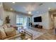 Bright living room with large sectional sofa, modern chandelier, and views of outdoor pool area at 2826 Riders Pass, Odessa, FL 33556