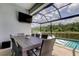 Covered outdoor dining area with a view of the pool and greenspace at 2826 Riders Pass, Odessa, FL 33556